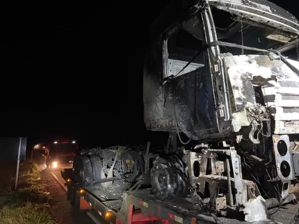 Caminhão carregado com amendoim pega fogo após colisão com Fiat Strada na BR-153