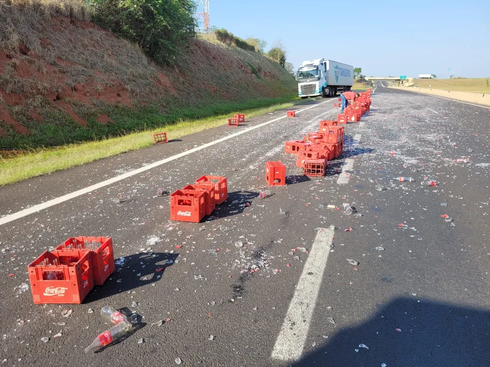 Caixas de garrafas de refrigerante caem de caminhão e ficam espalhadas em rodovia em Santa Cruz do Rio Pardo